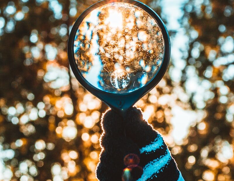 person holding black magnifying glass